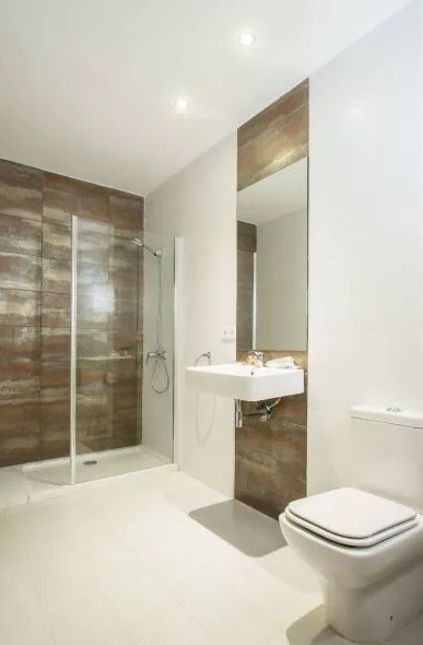 Modern bathroom featuring a glass walk-in shower, floating white sink, mirror, and a white toilet